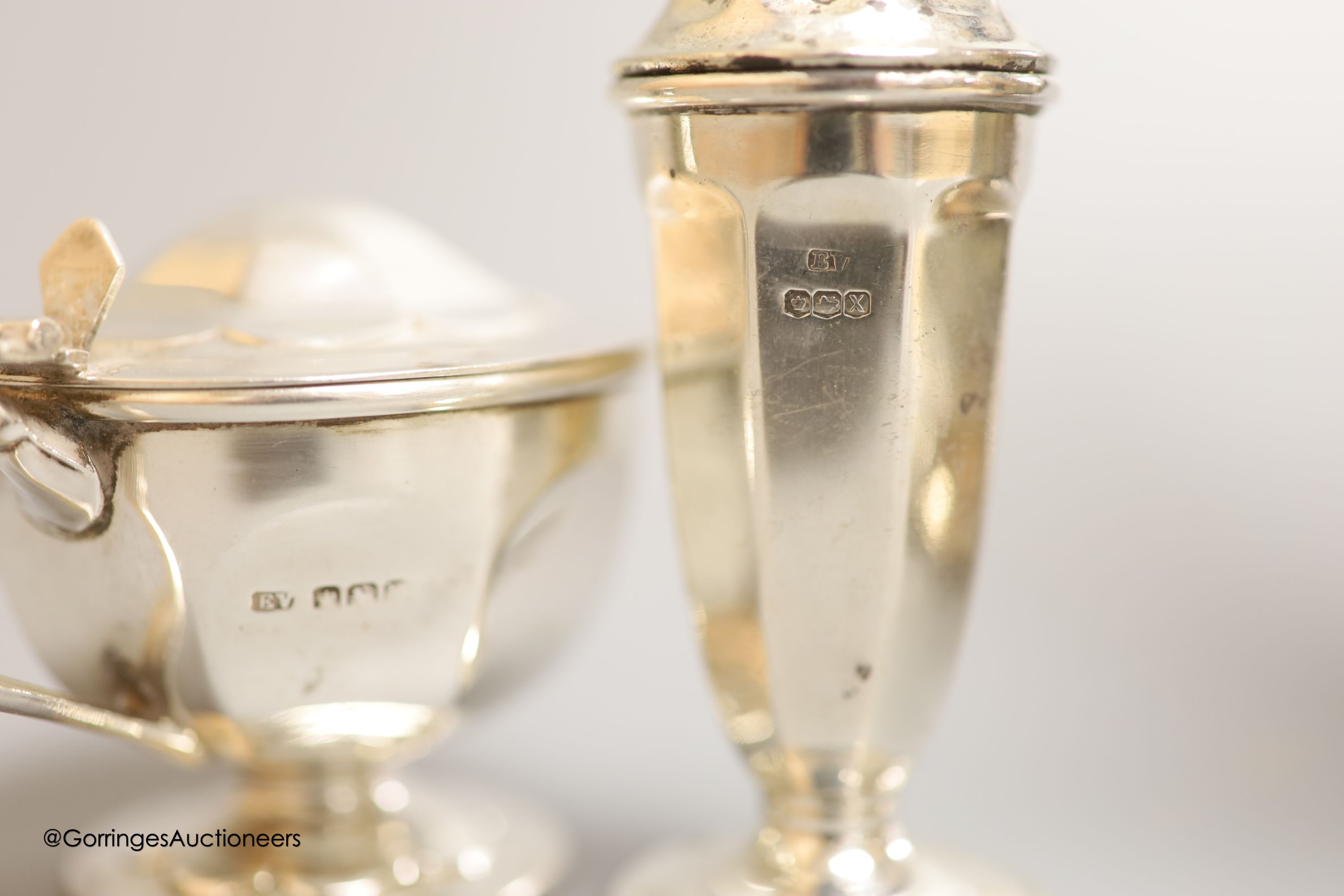 A cased pair of ornate Edwardian silver preserve spoons, Sheffield, 1905, a silver sauceboat, a silver hot water pot and two silver condiments